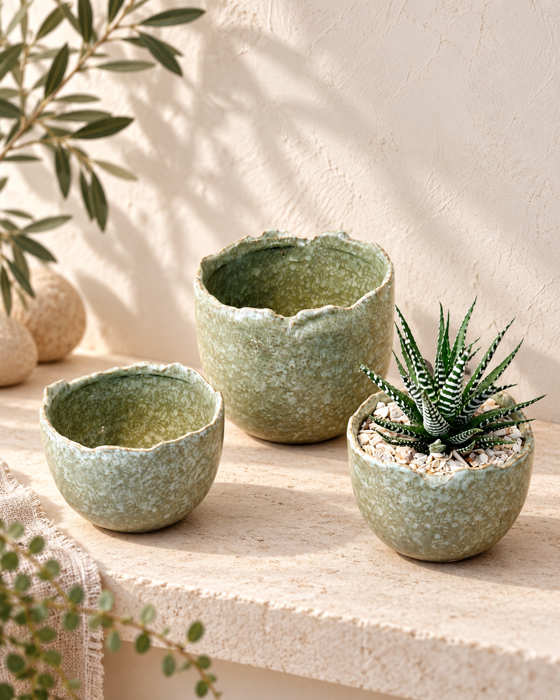 A characterful sage-green ceramic plant pot with a beautifully speckled glaze and organic uneven rim, perfect for succulents, small houseplants and seasonal bulbs.